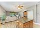 Bright living room featuring a center island, open floor plan, and sliding glass doors to the lanai at 135 River Enclave Ct, Bradenton, FL 34212