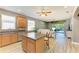 Open-concept living space with kitchen island, modern appliances, and a view to the outdoor living area at 135 River Enclave Ct, Bradenton, FL 34212