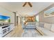 Spacious living room featuring wood-look floors, a large sofa, and easy access to the kitchen and dining area at 135 River Enclave Ct, Bradenton, FL 34212