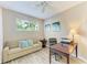 Comfortable home office with a sofa, desk, and natural light, perfect for a productive workspace at 135 River Enclave Ct, Bradenton, FL 34212