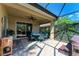 Covered patio featuring a seating area, sliding glass doors, and vibrant garden views at 135 River Enclave Ct, Bradenton, FL 34212