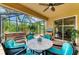 Inviting screened lanai with stylish furniture, complemented by lush, tropical views at 135 River Enclave Ct, Bradenton, FL 34212