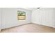 Cozy bedroom with bright white walls, two double closets, and a window with natural light and wood-look floors at 1406 N Riverhills Dr, Temple Terrace, FL 33617