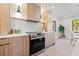 Bright kitchen features stainless steel appliances, modern wood cabinets, and a view to the breakfast nook at 1406 N Riverhills Dr, Temple Terrace, FL 33617