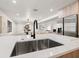 Close-up of the kitchen island, showcasing a deep stainless sink, white countertops, and stylish faucet at 1406 N Riverhills Dr, Temple Terrace, FL 33617