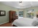 Bright bedroom featuring a tray ceiling, wood floors, and sliding doors to a pool area at 14404 18Th E Pl, Bradenton, FL 34212