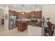 Well-equipped kitchen features dark wood cabinets, stainless steel appliances, and island counter with bar stools at 14404 18Th E Pl, Bradenton, FL 34212