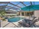 Relaxing screened-in pool area with lounge chairs and lush landscaping, perfect for outdoor enjoyment at 14404 18Th E Pl, Bradenton, FL 34212