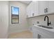Laundry room featuring a sink, cabinets, and a window for natural light at 193 Rotonda N Blvd, Rotonda West, FL 33947