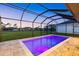 A backyard swimming pool has vivid purple lights, stylish tile, and a full screened enclosure at 193 Rotonda N Blvd, Rotonda West, FL 33947