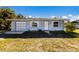 Charming single-story home with a garage, front lawn, and walkway to the front door at 203 Peacock Ln # B, Holmes Beach, FL 34217