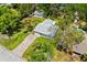 An aerial view of a charming home with a long brick driveway, lush greenery, and a detached garage at 2225 Alice Rd, Sarasota, FL 34231