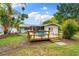 Large backyard with a wooden deck, seating area, and mature trees at 2225 Alice Rd, Sarasota, FL 34231