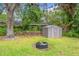 Backyard featuring a storage shed, firepit and ample area for recreational activities at 2225 Alice Rd, Sarasota, FL 34231