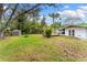 A full backyard view with a storage shed, fire pit, wooden deck, and well-maintained lawn at 2225 Alice Rd, Sarasota, FL 34231