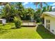 Lush backyard features a wood deck and lush tropical landscaping adjacent to a charming single-story home at 2225 Alice Rd, Sarasota, FL 34231