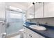 Bathroom featuring tile surround, a sliding shower door, and a white vanity at 2225 Alice Rd, Sarasota, FL 34231