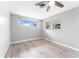 Charming bedroom with light-wood-look flooring, a ceiling fan and two windows at 2225 Alice Rd, Sarasota, FL 34231