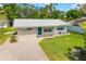 Charming single-story home with a manicured lawn, brick paver walkway, and vibrant blue front door at 2225 Alice Rd, Sarasota, FL 34231