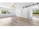 Bright living room featuring wood floors, a sliding barn door and natural light at 2225 Alice Rd, Sarasota, FL 34231