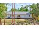 Backyard featuring a white home with a small deck and large yard with mature trees at 2425 21St St # B, Sarasota, FL 34234