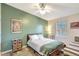 Cozy bedroom with light green accent wall, ceiling fan, and natural light from a window at 2425 21St St # B, Sarasota, FL 34234