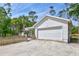 Exterior view featuring an attached garage, a graveled driveway, and manicured greenery at 2425 21St St # B, Sarasota, FL 34234