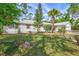 Charming single-story home featuring a lush, green lawn, mature trees, and red shutters at 2425 21St St # B, Sarasota, FL 34234