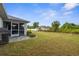 Spacious backyard with green lawn and screened-in patio, offering outdoor living and recreation at 2665 Chipley Ave, North Port, FL 34286