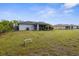 Spacious backyard featuring a screened lanai, lush lawn, and mature trees, perfect for outdoor enjoyment at 2665 Chipley Ave, North Port, FL 34286