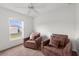 Inviting bedroom with a ceiling fan, two chairs, and a view of the backyard at 2665 Chipley Ave, North Port, FL 34286