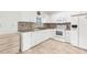 Bright kitchen with white cabinets, appliances, and tile backsplash at 2665 Chipley Ave, North Port, FL 34286