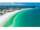 Stunning aerial view of the pristine beach and turquoise waters meeting the shoreline and coastal town at 2909 Concord St, Sarasota, FL 34231