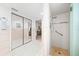 Bathroom featuring white tiling, mirrored closet and a step-in shower with grab bar at 2909 Concord St, Sarasota, FL 34231