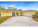 Lovely yellow home featuring a two car garage, beautiful landscaping, and a bright blue front door and shutters at 2909 Concord St, Sarasota, FL 34231