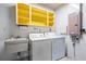Functional laundry room with a sink, washer, dryer, and bright yellow cabinets at 2909 Concord St, Sarasota, FL 34231