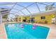 Inviting screened-in pool area with pink flamingo floaties and a sunny, yellow exterior at 2909 Concord St, Sarasota, FL 34231