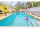 Inviting screened-in pool area with pink flamingo floaties and steps leading into the water at 2909 Concord St, Sarasota, FL 34231
