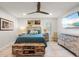 Bright bedroom featuring distressed wood furniture, ceiling fan, and beach-themed decor and tv at 303 Bryn Mawr Is, Bradenton, FL 34207