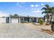 Charming single-story home featuring a paved driveway, garage, and manicured landscaping at 303 Bryn Mawr Is, Bradenton, FL 34207