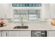 Bright kitchen with stainless steel sink, white cabinets, and marble countertops at 303 Bryn Mawr Is, Bradenton, FL 34207