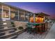 Outdoor bar area with stairs to patio in the evening, illuminated with string lights at 303 Bryn Mawr Is, Bradenton, FL 34207