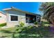 View of the house's exterior, showcasing the yard and screened-in lanai at 322 Langholm Dr, Venice, FL 34293