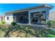 View of the house's exterior, showcasing the yard and screened-in lanai at 322 Langholm Dr, Venice, FL 34293