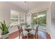 Cozy dining area with a glass table, seating for four, and views of the landscaped backyard at 322 Langholm Dr, Venice, FL 34293