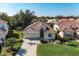 Aerial view of a well-maintained single-story home with tile roof, lush landscaping, and a manicured front lawn at 322 Langholm Dr, Venice, FL 34293