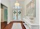 Bright foyer with hardwood floors, a chandelier, console table and beach-themed decorations at 322 Langholm Dr, Venice, FL 34293