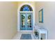 Inviting front entry with double doors, decorative wreaths, console table, and beach-themed decor at 322 Langholm Dr, Venice, FL 34293