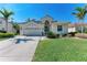 Charming single-story home featuring a well-manicured lawn, tropical landscaping and a tile roof at 322 Langholm Dr, Venice, FL 34293