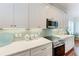 Bright kitchen features white cabinets, quartz countertops, stainless steel appliances, and a stylish backsplash at 322 Langholm Dr, Venice, FL 34293